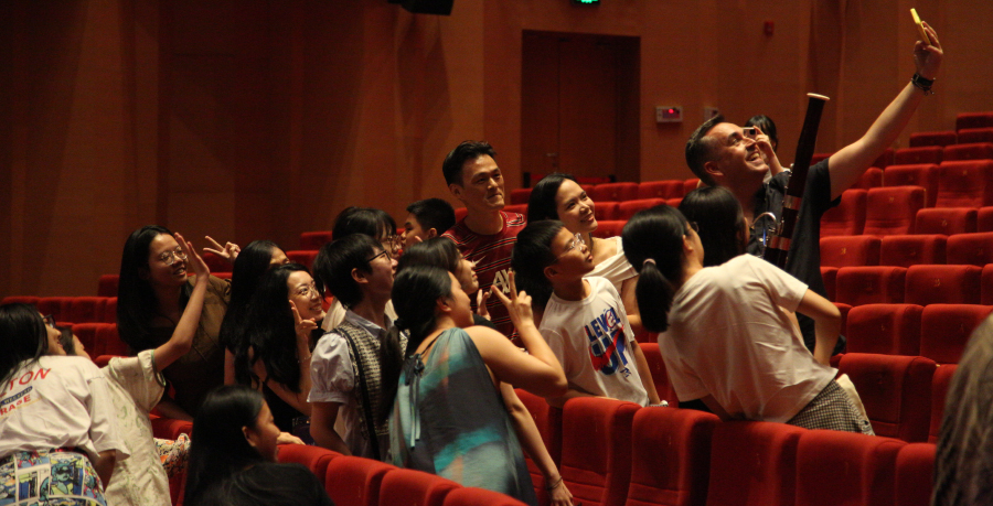 RPO Principal Contrabassoon Fraser Gordon taking a selfie with audience members and Ray Chen