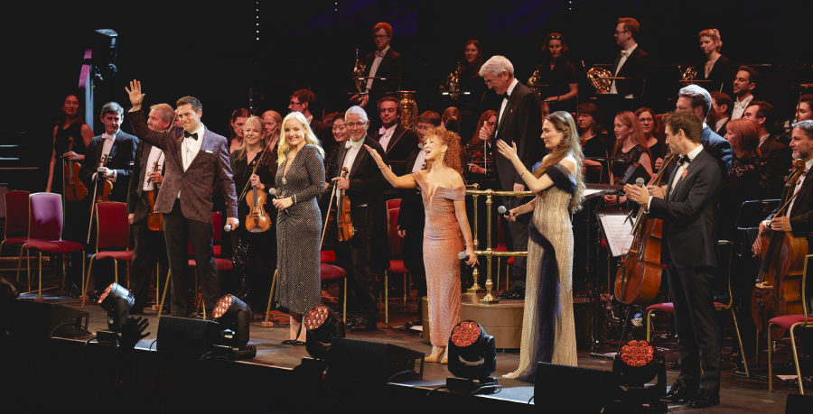 Four vocalists and presenter Bonnie Langford standind on stage at the Royal Albert Hall with the RPO to receive applause