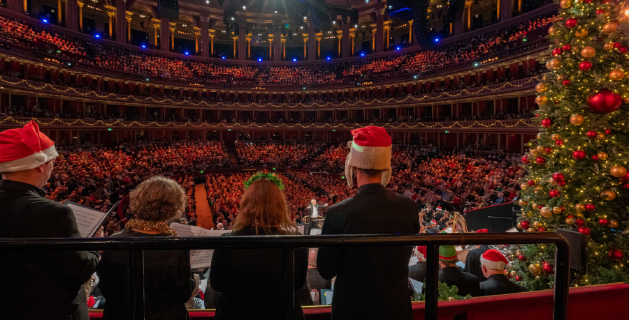 Singers in Christmas gear at a full Royal Albert Hall