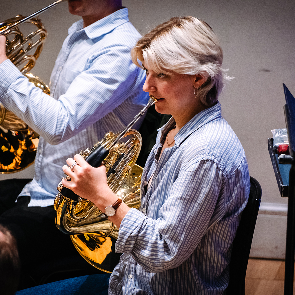 Zoe Tweed playing her horn in rehearsal at Cadogan Hall