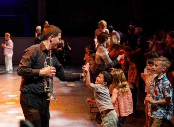 A trumpeter in the RPO high fives a young member of the audience at a relaxed performance