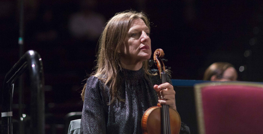 RPO Player Kay Chappell sitting with her violin in rehearsal.