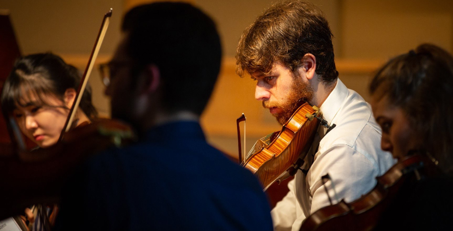 Leonardo Jaffe playing the violin in rehearsal